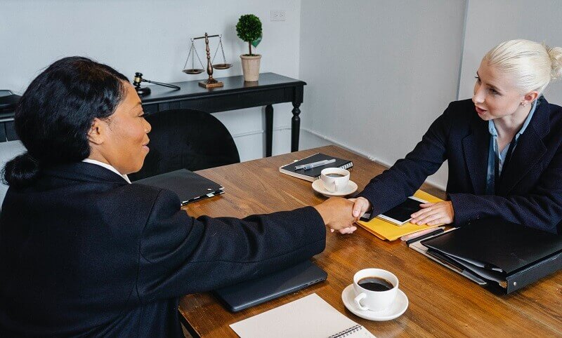 businesswomen shaking hands during meeting