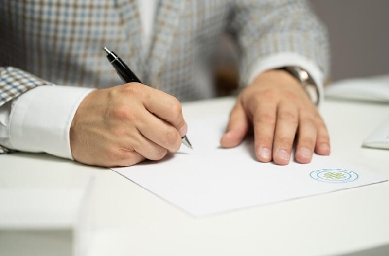 man signing a document