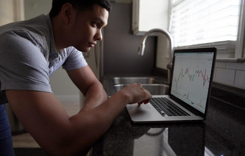 man checking company sales graph on laptop