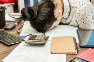 woman holding on the head in table