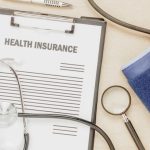 health insurance papers and sethoscope with pulse guage