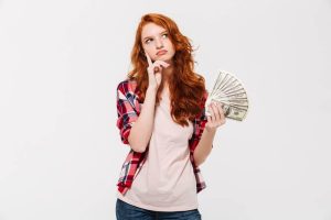 girl thinking and hold money in the hand